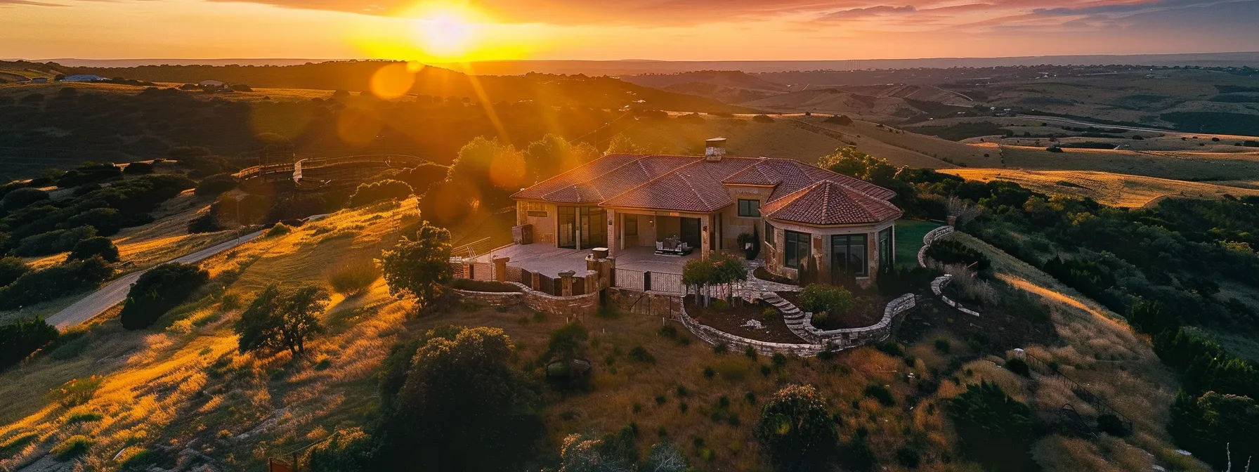 a stunning aerial shot of a newly built home at sunset, showcasing its unique design and beautiful surroundings.