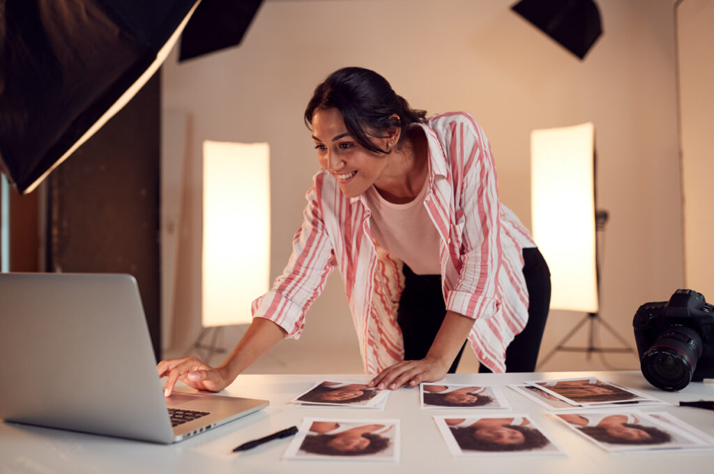 Female Photographer Editing Images From Photo Shoot In Studio - Home Builder Marketers